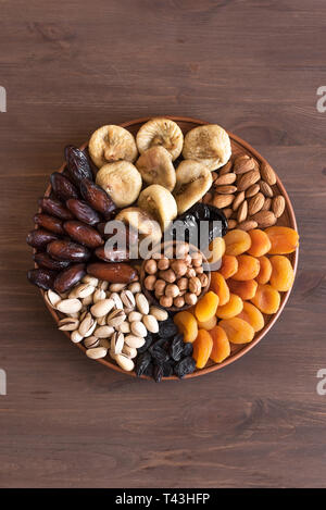 Getrocknete Früchte und Nüsse am Platter, Ansicht von oben. Vegetarische gesunde Süßigkeiten auf Holz, kopieren. Traditionelle muslimische Iftar Essen zum Ramadan. Stockfoto