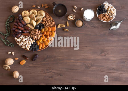 Traditionelle muslimische Iftar Essen auf Holz-, kopieren. Ramadan Kareem mit Datteln, Nüsse, getrocknete Früchte und Kaffee. Ramadan iftar Essen Konzept mit Rosenkranz. Stockfoto