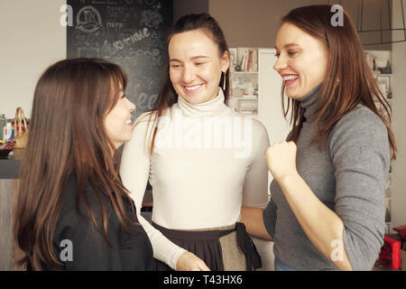 Drei Frauen, die Freunde zusammen, umarmt Gruß. Freundlich treffen im Cafe. Freundschaft Konzept. Stockfoto