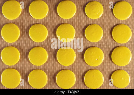 Kochen Makronen auf Schablone Silikon Matte auf dem Tisch, Blick von oben. close-up. Stockfoto