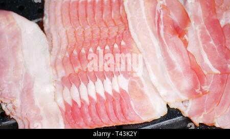 Schließen Sie herauf Bild von mehreren Streifen Speck in der Pfanne. Flach Stockfoto