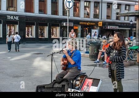Norwegen, Oslo. August 1, 2013. Musiker und Mädchen singen im Quadrat in Oslo, der Hauptstadt Norwegens. Zusätzliche Einkommen. Editorial. Stockfoto
