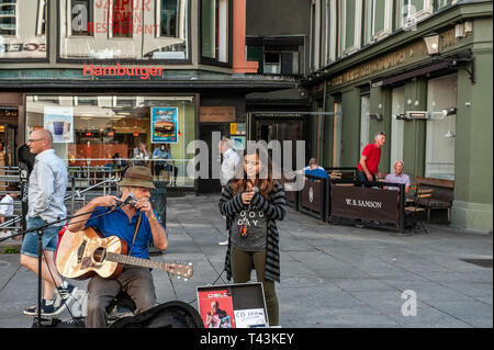 Norwegen, Oslo. August 1, 2013. Musiker und Mädchen singen im Quadrat in Oslo, der Hauptstadt Norwegens. Zusätzliche Einkommen. Editorial. Stockfoto
