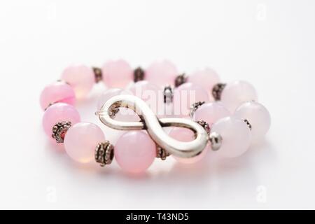 Wunderschöne Armband mit rosa Opal stones Unendlichkeit, handgefertigten Schmuck, Perlen Armband auf weißem Hintergrund Stockfoto