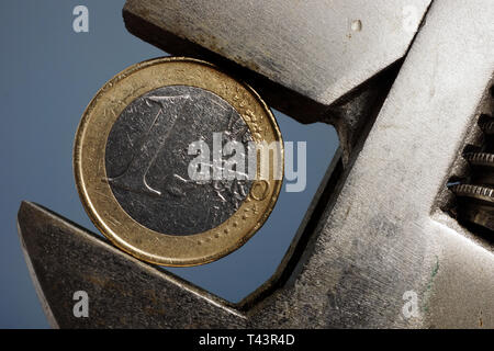 Euro Münze Zange zusammengedrückt. Finanzkrise und die Inflation in Europa Konzept. Stockfoto