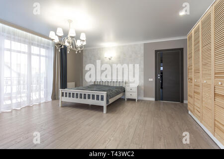 Holz Bett im Inneren des modernen Schlafzimmer im Loft Wohnung in teuren Wohnungen Stockfoto