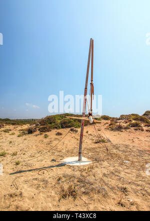 Sonne scheint zu klein gebrochen Wind Turbine in trockenen, Wüste wie Land. Post-apokalyptischen Ödland Szene. Stockfoto