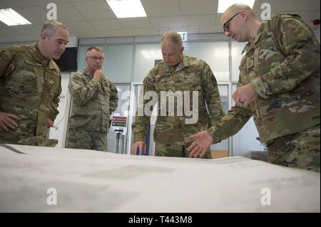 Us Air Force Oberstleutnant Shannon Kaleb, 726Th Air Mobility Squadron Commander, Mitte links und US Air Force Master Sgt. Anthony Biecheler, 726Th AMS Personenverkehr Betriebsleiter, rechts, zeigen die 2021 Passenger Terminal Renovierung plant die US Air Force Generalmajor John Gordy, US Air Force Expeditionary Center Commander, Mitte rechts, und US Air Force Chief Master Sgt. Kristopher Berg, US Air Force Expeditionary Zentrum Befehl Chief, Links, in Spangdahlem Air Base, Deutschland, 13. März 2019. Die 726Th AMS sucht mehr Raum in die PAX-terminal hinzuzufügen. Stockfoto