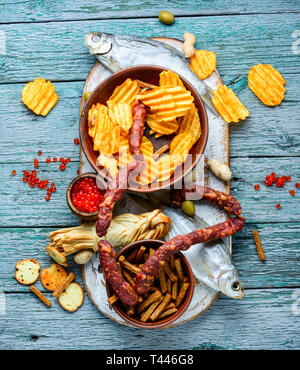 Auswahl an Bier und Snacks. Pommes, Fisch, Bier, Würstchen auf den Tisch Stockfoto