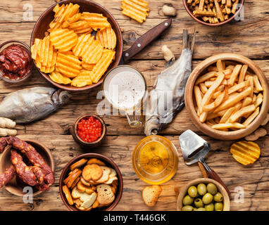 Auswahl an Bier und Snacks. Pommes, Fisch, Bier, Würstchen auf den Tisch Stockfoto