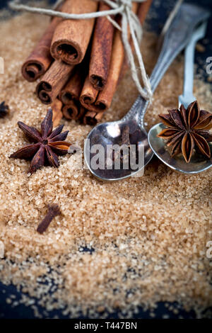 Brauner Rohrzucker, Zimtstangen, Sternanis closeup auf Schwarzes Brett Hintergrund. Mit kopieren. Stockfoto