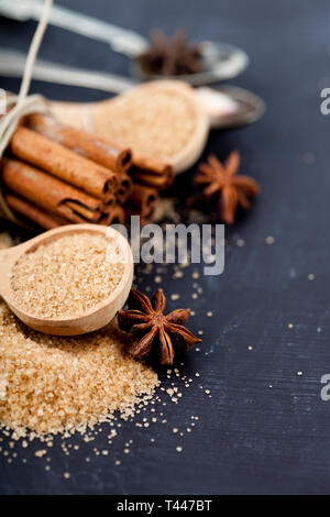 Brauner Rohrzucker, Zimtstangen, Sternanis closeup auf Schwarzes Brett Hintergrund. Mit kopieren. Stockfoto