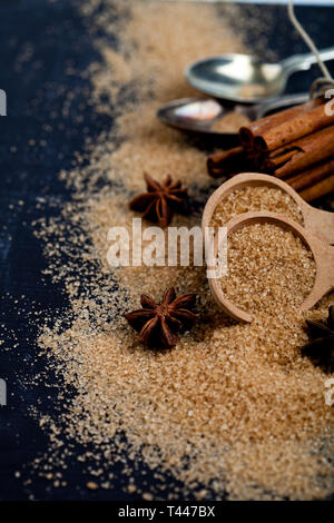 Brauner Rohrzucker, Zimtstangen, Sternanis closeup auf Schwarzes Brett Hintergrund. Mit kopieren. Stockfoto