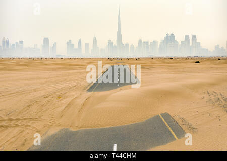 Ansicht von oben, atemberaubenden Blick auf eine einsame Straße durch Sanddünen in der Mitte des Dubai Wüste bedeckt. Stockfoto