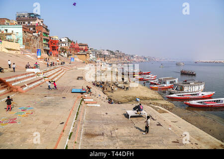 Luftbild des Ganges in Varanasi mit antiken Architektur, Holz- boote und Kinder spielen und Drachen steigen Stockfoto