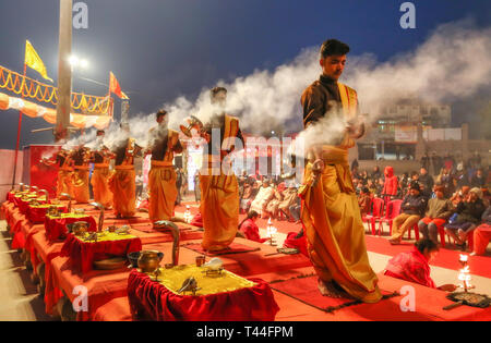 Jungen Hindu Priester führen traditionelle Ganga Aarti Zeremonie Rituale mit Feuer vor Sonnenaufgang auf dem Ganges in Varanasi, Indien. Stockfoto