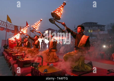 Jungen Hindu Priester führen traditionelle Ganga Aarti Zeremonie Rituale mit Feuer vor Sonnenaufgang auf dem Ganges in Varanasi, Indien. Stockfoto