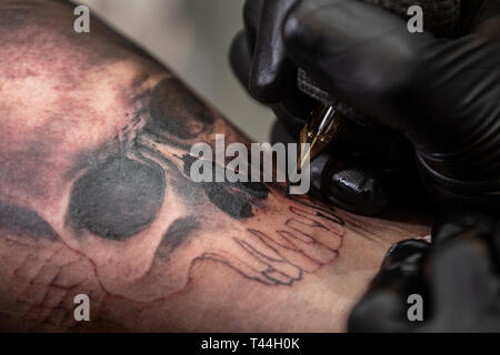 Ein Meister macht ein Tattoo an der Tattoo Festival in Moskau, Russland Stockfoto