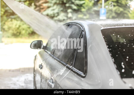 Seitenfenster des Autos in selbst gewaschen dienen Waschstraße, Hochdruckreiniger Wasser spritzen auf Glas. Stockfoto