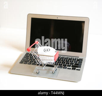 Online shopping Konzept: Katze auf einem Laptop Tastatur mit dem E-Mail-Symbol auf es-signifikanten Shopping online Stockfoto