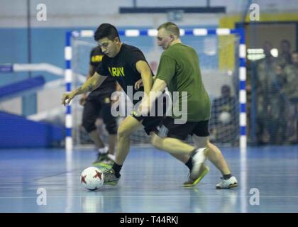 SKWIERZYNA, Polen (Feb. 21, 2019) - eine US-amerikanische und Polnische Spieler Kampf um den Ball während eine freundliche futsal Spiel zwischen Soldaten von 101 Brigade Support Bataillons, 1st Armored Brigade Combat Team, 1.Infanterie Division, und polnische Soldaten, hier, 24.02.21. Futsal ist eine Variante des Standard outdoor Fußball, auf einem Hartplatz und in der Regel im Innenbereich gespielt. Stockfoto