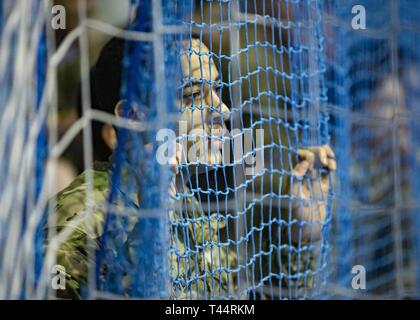 SKWIERZYNA, Polen (Feb. 21, 2019) - ein Soldat und Lüfter von 101 Brigade Support Bataillons, 1st Armored Brigade Combat Team, 1.Infanterie Division, Uhren mit Vorfreude während einer freundlich futsal Spiel mit der polnische Soldat basic Auszubildende, hier, 24.02.21. Futsal ist eine Variante des Standard outdoor Fußball, auf einem Hartplatz und in der Regel im Innenbereich gespielt. Stockfoto