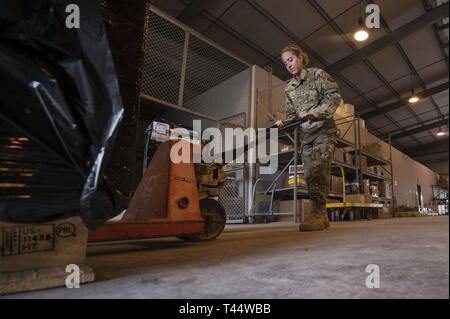 Senior Airman Chelsey Burkus, 379 Expeditionary Logistik Bereitschaft Squadron (ELRS) Traffic Management Office (TMO) Verkehrsmanagement Facharbeiter, bereitet eine Palette Februar 22, 2019 zu bewegen, im Al Udeid Air Base, Katar. Die 379 ELRS TMO übernimmt die Abholung, Lagerung, Versand und Lieferung von Vermögenswerten wie kleine Teile des Fahrzeugs, Flugzeugmotoren, und Bekleidung Artikel während des US Central Command Verantwortungsbereich. Stockfoto