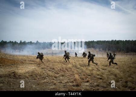 Us-Armee Fallschirmjäger zu Charlie Company, 2nd Battalion, 505Th Parachute Infantry Regiment, 3. Brigade Combat Team, 82nd Airborne Division durch ein Feld in Richtung einer simulierten Feind compound während einer Live-fire Übung 24.02.2019, am Fort Bragg, North Carolina gebunden. Stockfoto