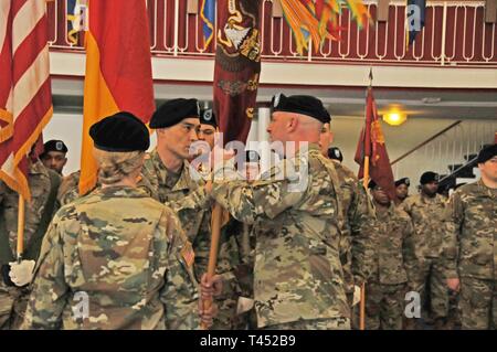 Command Sgt. Maj. Michael D. Russell, Senior Advisor angeworben, 39th Transport Bataillon (Kontrolle), 16 Sustainment Brigade, leitet die Einheit Farben Oberstleutnant William R. Kost, ausgehende Bataillonskommandeur, während eine Änderung der Befehl Zeremonie an der Armstrong Club, Kaiserslautern, Deutschland, Feb.26, 2019. Während der Zeremonie, Kost offiziell übergeben die Rechenschaftspflicht, die Obrigkeit und das Kommando des Bataillons Oberstleutnant Brandon H. Ungetheim, eingehende Bataillonskommandeur. Stockfoto