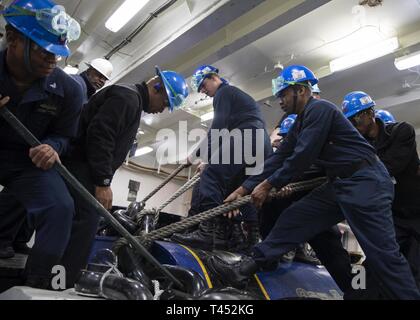 NEWPORT NEWS, Virginia (Feb. 27, 2019) Segler auf USS Gerald R. Ford's (CVN 78) deck Abteilung lift Ford's Kette auf eine Wildkatze anker zugeordnet. Ford wird derzeit in post-shakedown Verfügbarkeit Huntington Ingalls Industries-Newport Nachrichten Schiffbau. Stockfoto