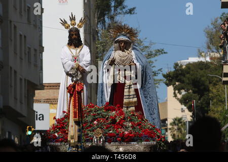 April 13, 2019 - 13 April 2019 (Malaga) wenige Minuten nach sieben Uhr morgens und mit Jesus und der Jungfrau der Dreifaltigkeit auf seinem Thron der Übertragung und unter den Sturz der Kirche von San Pablo, die traditionelle Masse von Dawn hat begonnen, amtiert vom Bischof der Diözese, Jesus Catala. Nach acht Uhr, die Übertragung durch die Straßen der Dreifaltigkeit hat begonnen, die Bilder auf ihre Throne der Prozession zu nehmen, warten auf die Parade der Heiligen Montag. Credit: Lorenzo Carnero/ZUMA Draht/Alamy leben Nachrichten Stockfoto