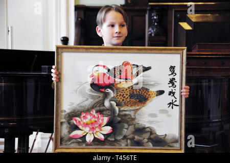 Riga, Lettland. 12 Apr, 2019. Ein Junge zeigt ein Kunstwerk in der 16. chinesischen Brücke Chinese proficiency Wettbewerb in der Universität von Lettland in Riga, Lettland, am 12. April 2019. 16. Chinesische Brücke, eine jährliche Chinesische Sprachkenntnisse Wettbewerb für Schüler, Studenten und erwachsene Lernende der Chinesisch, wurde an der Universität von Lettland Freitag und Samstag statt. Credit: Janis/Xinhua/Alamy leben Nachrichten Stockfoto