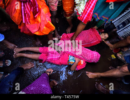 Kolkata, West Bengal, Indien. 13 Apr, 2019. Kinder gesehen, die auf der Straße, während die Anhänger schritt sie mit ihren Füßen während der gajan Festival. Gajan Festival ist ein Hindu traditionelle Volksfest findet hauptsächlich in den östlichen Teil von Indien am Ende der bengalischen Jahr/Mitte April, wo die Menschen verkleiden sich als unterschiedliche Hindu Gott und dabei verschiedene rituelle Praktiken wie Kinderschminken, Piercing, mit dem Feuer spielen ihren Glauben/Gott für das Wohlbefinden der Familie Credit: Avishek Das/SOPA Images/ZUMA Draht/Alamy Leben Nachrichten zu befriedigen gefeiert. Stockfoto