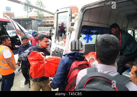 Kathmandu, Nepal. 14 Apr, 2019. Die Beamten tragen und die Leichen der Opfer im Flugzeug Kollision in der Nepalesischen Lukla Airport zum Teaching Hospital in Kathmandu, Nepal, 14. April 2019 getötet. Mindestens zwei Menschen wurden getötet, nachdem ein Flugzeug von Gipfel Luft mit einem Hubschrauber am Flughafen Lukla in Nepal am Sonntag Morgen zusammenstieß, nach Angaben der örtlichen Behörden. Credit: Sunil Sharma/Xinhua/Alamy leben Nachrichten Stockfoto