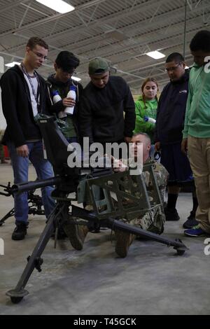 RAEFORD, N.C. - North Carolina National Guard Staff Sgt. Anthony Faso, zu der 105 Ingenieur Bataillon zugeordnet, Hands-on Training eines Mk19 Granatwerfer und anderen Waffen zu High School Studenten aus Raeford und südlichen Regionen von NC während des NCNG Guard X Challenge am 13.02.23., 2019. Dies ist der erste Guard X event Partnerschaften lokale Guard line-Einheiten, wie der 105 Ingenieur Bataillon mit NCNG Recruiting und Retention. Stockfoto