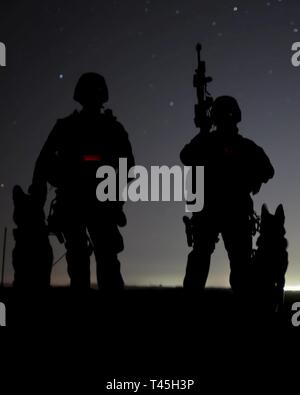 Us Marine Corps Cpl. David Hudson (Links) und Lance Cpl. Alexis Farias (Rechts), K9handler, die derzeit mit dem militärischen Gebrauchshund (MWD) Team Bereitstellung Ausbildung zugewiesen, posieren für ein Foto mit den MWD Freddie (Links) und Corado (rechts) bei der Durchführung von Schulungen auf der Yuma Proving Ground (YPG), Februar 25, 2019. Die MWD-Team Bereitstellung Schulung ist eine dreiwöchige Kurs, in dem MWD-Handler aus allen drei Marine Expeditionary Kräfte ihren Hund team Fähigkeiten durch die Fokussierung auf lehrerteams effektiver und tödliche Vermögen voraus. Stockfoto