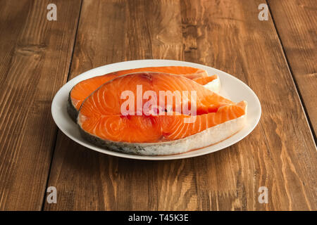 Zwei Stücke von frischem salmom Steak auf einem Schild auf hölzernen Tisch Stockfoto