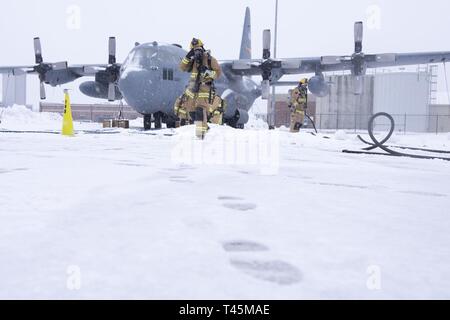Feuerwehrmänner zugeordnet zu der 103 Bauingenieur Squadron reagieren auf einen simulierten C-130 Hercules Motor Feuer, das am 2. März 2019, auf der Flightline von Bradley Air National Guard Base, East Granby, Anschl. Die Simulation wurde ein Teil einer Betriebsbereitschaft Ausübung gehalten auf der Basis März 2 - 3, 2019. Stockfoto