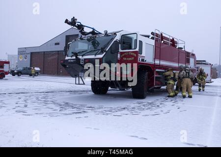 Feuerwehrmänner der 103 Bauingenieur Geschwader zugewiesen zu einem simulierten C-130 Hercules Motor Feuer, das am 2. März 2019, auf der Flightline von Bradley Air National Guard Base, East Granby, Anschl. Die Simulation wurde ein Teil einer Betriebsbereitschaft Übung auf der Basis März 2 - 3, 2019 statt zu reagieren. Stockfoto