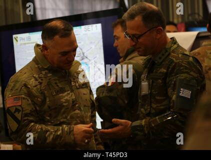 Generalmajor Paul Calvert (links), der kommandierende General der Kavallerie Division 1 stellt Informationen aus der griechischen Armee Oberstleutnant Smyrna Panagiotis, während der übung Dynamische Front 19, am 4. März Grafenwöhr Training Area, Deutschland. Dynamische Vordere 19 ist eine multinationale Übung der US-Armee in Europa zur Verbesserung der Alliierten und Partner nation Fähigkeit zu lange liefern - Bereich Feuer. Es ermöglicht Verbündeten persönlich, fachlich, technisch und taktisch stärker und fähiger Kräfte in der Zeit der Krise zu schaffen. Stockfoto