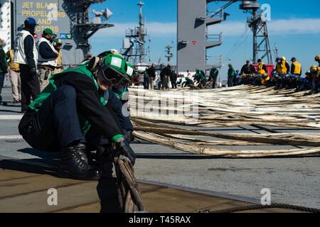 Virginia (7. März 2019) Segler rig eine Barrikade während Flight Deck Bohrer an Bord der Flugzeugträger USS Dwight D. Eisenhower (CVN 69). Ike ist zurzeit eine geplante schrittweise Verfügbarkeit (PIA) an der Naval Station Norfolk während der Erhaltungsphase der optimiert Flotte Notfallplan (OFRP). Stockfoto