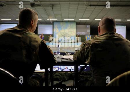 Rhein ORDNANCE BARRACKS, Deutschland - Command Sgt. Maj. Rocky L. Carr, 21 Theater Sustainment Command und Maj Gen Steven Shapiro, 21 TSC kommandierender General, hören eine kurze Erläuterung sustainment Operationen während der US-Armee Europa Sustainment Probe von Konzept Bohrmaschine Freitag, März 8, 2019 in Kaiserslautern, Deutschland. Stockfoto