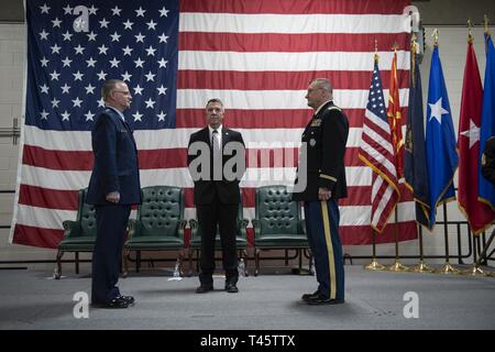 Us Air Force Generalmajor Steven Cray, Links, Adjutant General, National Guard, Vermont Vermont Governor Phil Scott und US-Armee Oberst Gregor Ritter für eine Weitergabe der Farben bei einem Befehl Zeremonie der Adjutant General der Vermont National Guard auf Lager Jonson, Colchester, Vt, 3. März 2019 vorzubereiten. Nach sechs Jahren des Befehls, US Air Force Generalmajor Steven Cray Befehl, der U.S. Army Colonel Gregory Ritter, die in die Stellung, die die Vermont Gesetzgebung am 21. April gewählt wurde aufgegeben. Stockfoto