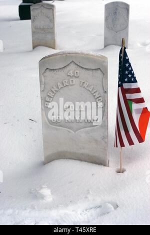 Ein amerikanischer und irischer Flagge Mark das Grab von Pvt. Bernard Trainor einen Soldaten in die 69Th New York Volunteer Infantry Regiment während des Bürgerkriegs nach einer Flagge die Zeremonie, in der Soldaten viel in Albany ländlichen Friedhof am 10. März 2019. Trainor wurde während der Schlacht von Gettysburg 1863 verwundet und in ein Krankenhaus nach Albanien geschickt. Er starb im Jahre 1868. Veteranen des ersten Bataillons 69th Infanterie der New Yorker Nationalgarde, die in Albany, New York, live-Bereich die Gräber der Iren - amerikanische Bürgerkrieg Soldaten in Albanien der ländlichen Friedhof und St. Agnes katholischen Friedhof markiert das Li zu bestätigen Stockfoto