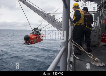 Philippinischen MEER (10. März 2019) Segler aus der Rächer - Klasse meine Gegenmaßnahmen Schiff USS Pioneer (MCM 9) unteren eine Mine Neutralisation Fahrzeug (NMV) in das Wasser minenjagd Übungen durchzuführen. Pionier, Teil der Mine Countermeasure Squadron 7, ist die in den USA 7 Flotte Einsatzgebiet Interoperabilität mit Partnern zu verbessern und dienen als eine fertige Antwort Plattform für Blindbewerbungen. Stockfoto