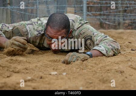 Kapitän Justin Bingham, Infanterie Offizier, an die Vereinten Nationen Befehl Sicherheit Bataillon, Joint Security Area zugeordnet, kriecht der unteren Bauch sollst du kriechen, Teil des Parcours Event während der 210Th Field Artillery Brigade 2019 besten Krieger Wettbewerb, Camp Hovey, Republik Korea, 12. März 2019. Der Wettbewerb diente als wertvolle Erfahrung, und die Gewinner werden auf die 2 Infanterie Division voraus besten Krieger Wettbewerb April 2019. Stockfoto