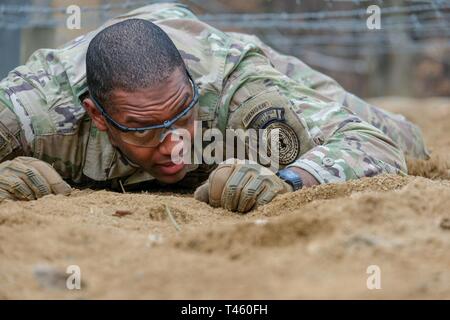 Kapitän Justin Bingham, Infanterie Offizier, an die Vereinten Nationen Befehl Sicherheit Bataillon, Joint Security Area zugeordnet, kriecht durch die niedrigen Bauch sollst du kriechen, Teil des Parcours Event während der 210Th Field Artillery Brigade 2019 besten Krieger Wettbewerb, Camp Hovey, Republik Korea, 12. März 2019. Der Wettbewerb diente als wertvolle Erfahrung, und die Gewinner werden auf die 2 Infanterie Division voraus besten Krieger Wettbewerb April 2019. Stockfoto