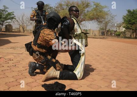 Burkina Faso Soldaten, spezielles Programm Botschaft Augmentation Antwort (Speer) einer terroristischen Schauspieler während eines simulierten Geiselnahme in Ouagadougou, Burkina Faso am 13.02.27, 2019 begreifen. Den Speer Soldaten gezeigt, ihre Fähigkeiten zu-Botschafter Andrew Young und mehrere andere. Stockfoto