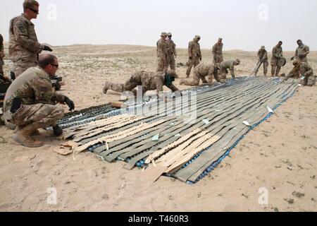 UDAIRI BEREICH, Kuwait (Feb. 27, 2019) - Soldaten der Task Force spartanisch und Fliegern aus der 407. und 386. Expeditionary Bauingenieur Staffeln zusammen arbeiten Blatt Sprengstoff bis 40 mm Munition anzuwenden, damit es entsorgt werden während einer kontrollierten Sprengung auf der Udairi Bereich, Kuwait, Feb.27, 2019 werden kann. Die ordnungsgemäße Entsorgung von unbrauchbaren Munition, wie diese 40 mm Runden, können lokale Munition holding Bereiche mehr Munition, die im lokalen Veranstaltungen oder sonstigen Verpflichtungen verwendet werden können, sobald sie auftreten. Stockfoto