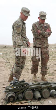 UDAIRI BEREICH, Kuwait (Feb. 27, 2019) - Brigadier General Charles Kemper, stellvertretender kommandierender General für Support, 34 Red Bull Infanterie Division, Task Force spartanisch, spricht mit Sgt. Gabriel Leon, 705Th Beseitigung von Explosivstoffen, Task Force Höllenhund, Task Force spartanisch, über die ORDNANCE in dieser Schuß pit aufgenommen vor einer kontrollierten Sprengung von mehr als 6.800 Pfund unbrauchbare Munition auf dem Udairi Bereich, Kuwait, Jan. 27, 2019. Kemper in die Gebühren für die vier separaten Schuß Gruben unterstützt. Stockfoto